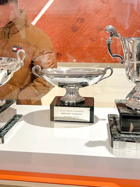 Trophies displayed at Roland-Garros Stadium, including Coupe Simone Mathieu and Coupe Marcel Bernard.