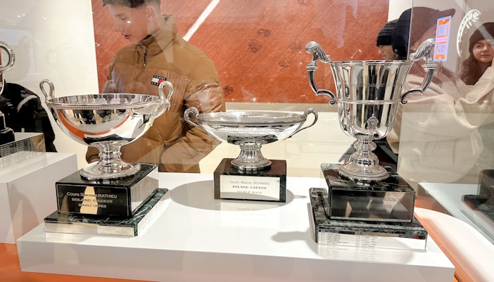 Trophies displayed at Roland-Garros Stadium, including Coupe Simone Mathieu and Coupe Marcel Bernard.