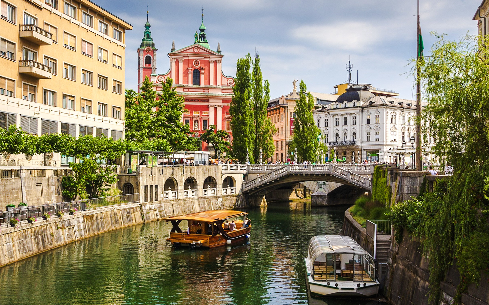 Boat on Ljubljanica River with view of Franciscan Church, Ljubljana, Slovenia.