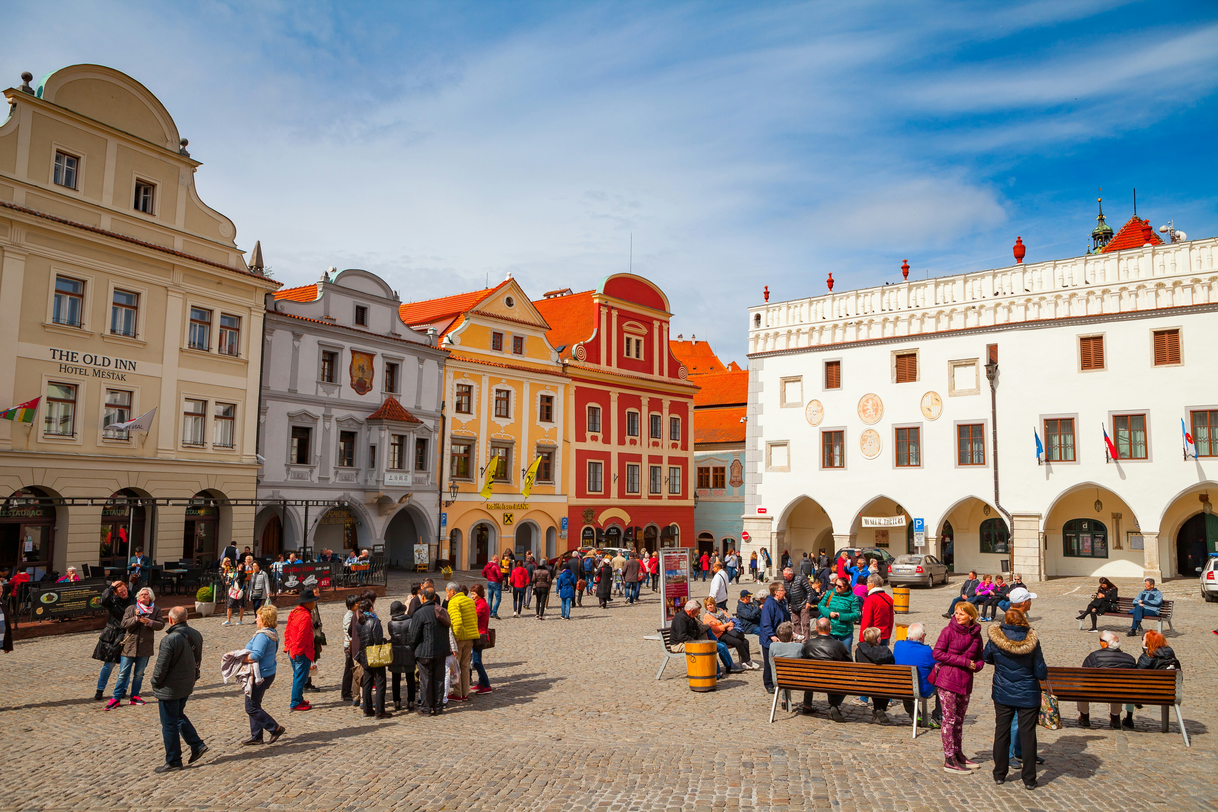 Cesky Krumlov main square with historic buildings and tourists exploring.