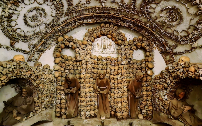 Capuchin Crypt in Rome Catacombs with monk statues and skull decorations.