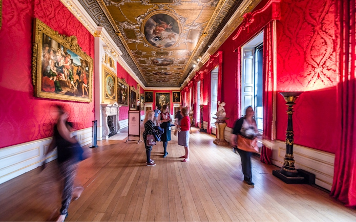 Visitors exploring the ornate gallery of Kensington Palace, London.