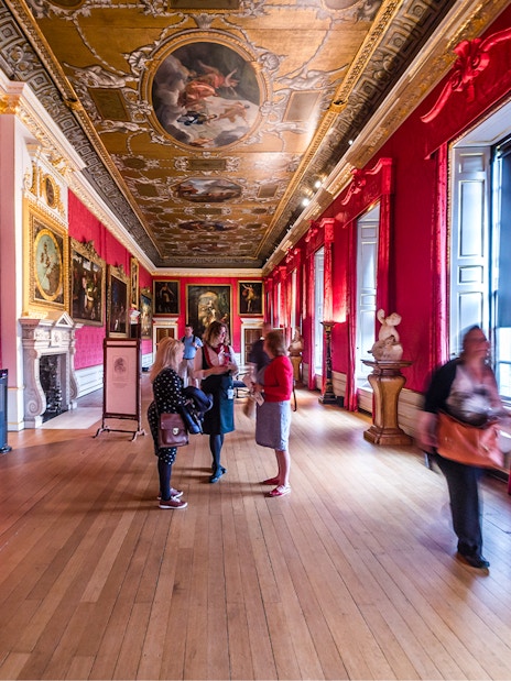 Visitors exploring the ornate gallery of Kensington Palace, London.