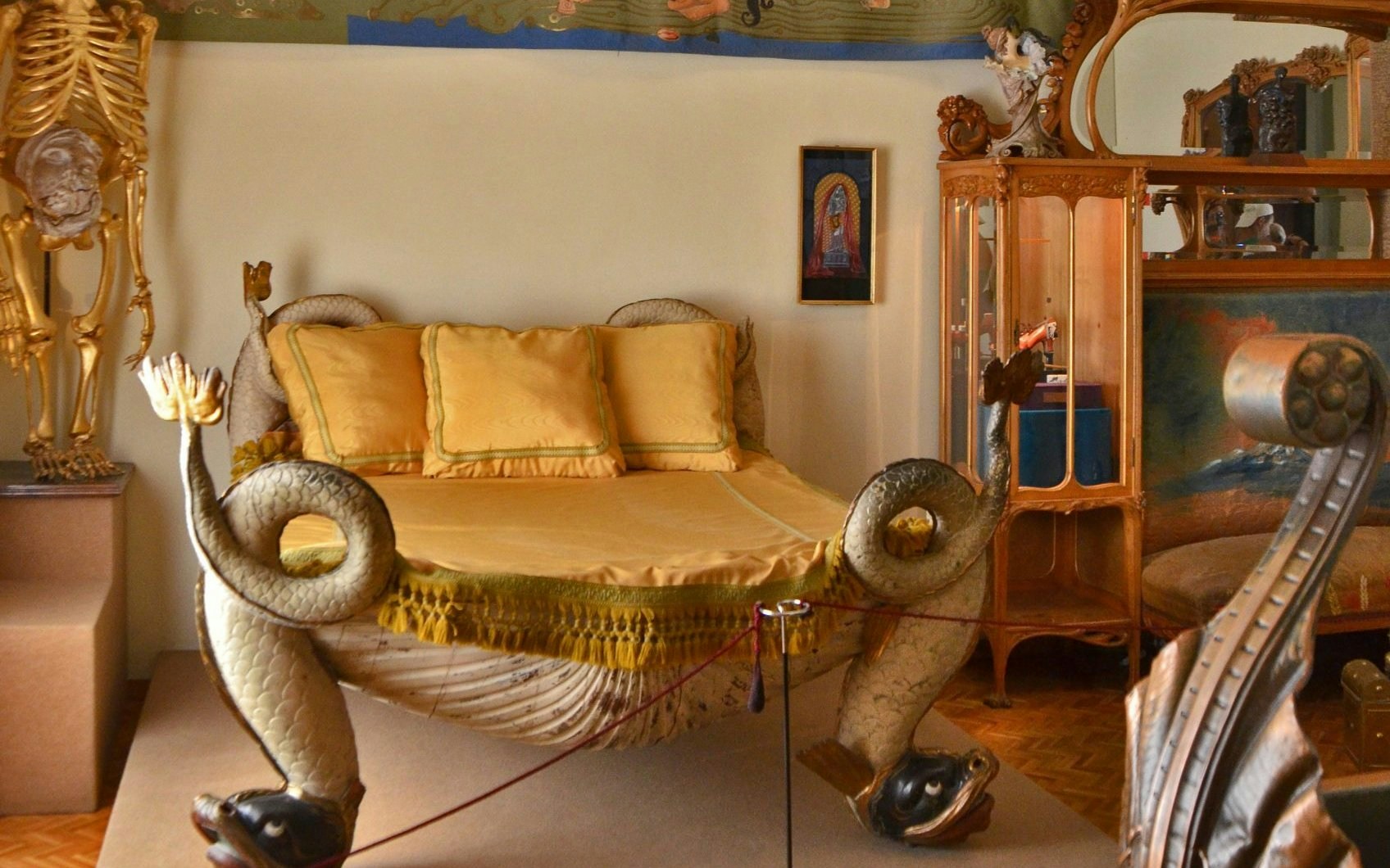 Surrealist bedroom with ornate bed featuring serpent designs and eclectic decor.