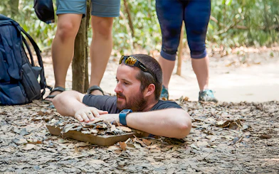 Man emerging from Cu Chi Tunnel in Vietnam.