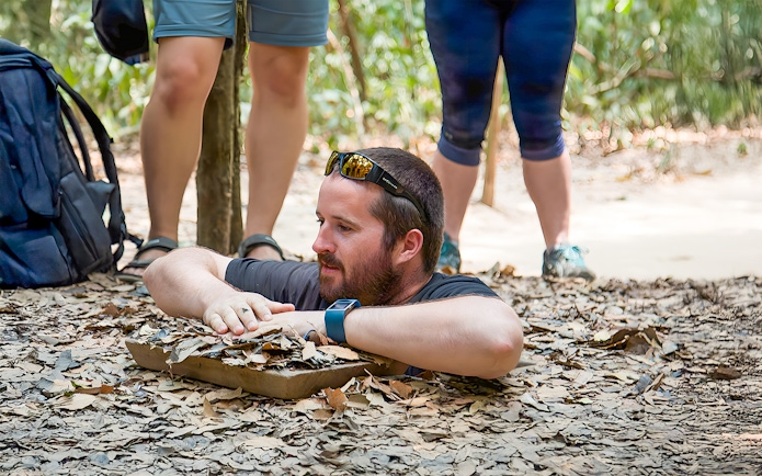 Man emerging from Cu Chi Tunnel in Vietnam.