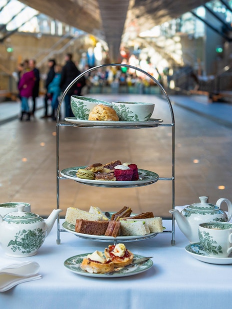 Afternoon tea setup with pastries and sandwiches at Cutty Sark, London.
