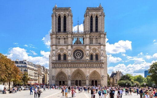 Notre Dame Cathedral exterior with a group of tourists in Paris.