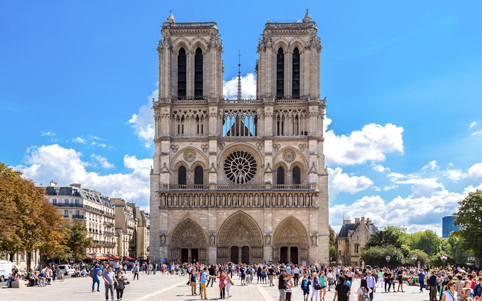 Notre Dame Cathedral exterior with a group of tourists in Paris.