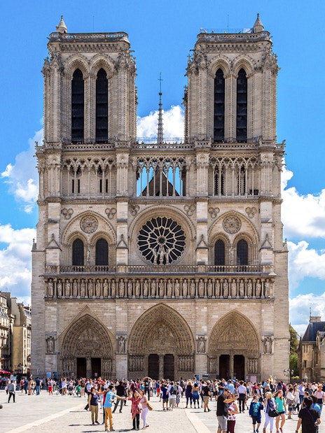 Notre Dame Cathedral exterior with a group of tourists in Paris.