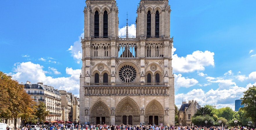 Notre Dame Cathedral exterior with a group of tourists in Paris.