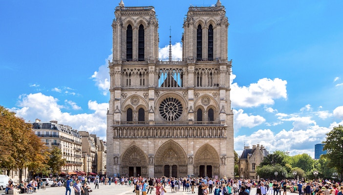Notre Dame Cathedral exterior with a group of tourists on a walking tour in Paris.
