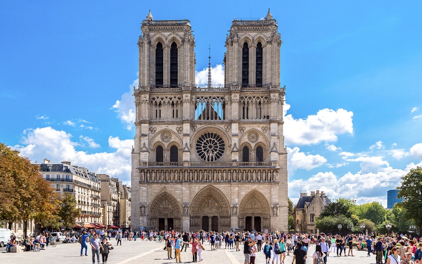 Notre Dame Cathedral exterior with a group of tourists in Paris.