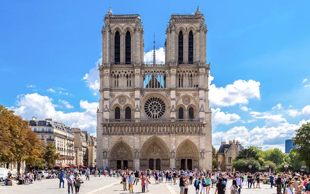 Notre Dame Cathedral exterior with a group of tourists in Paris.