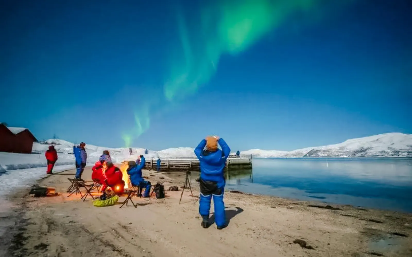 Guests viewing northern lights on Tromso beach during Northern Lights Chase tour.