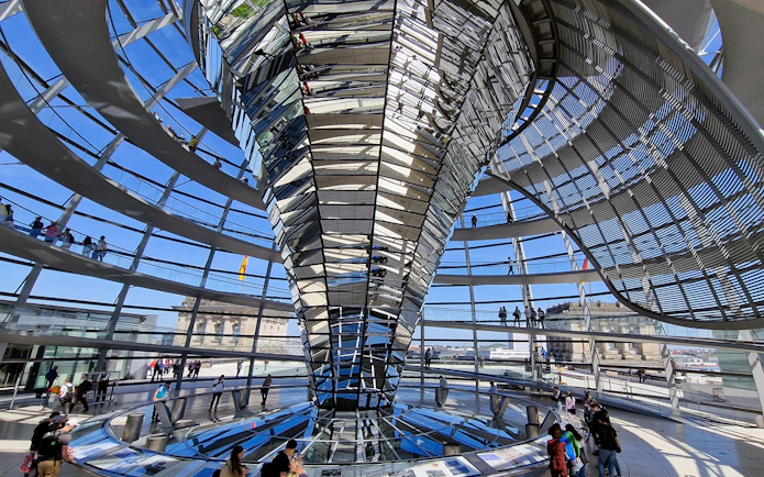 Interior view of the Reichstag dome in Berlin, showcasing the spiral walkway and glass structure.