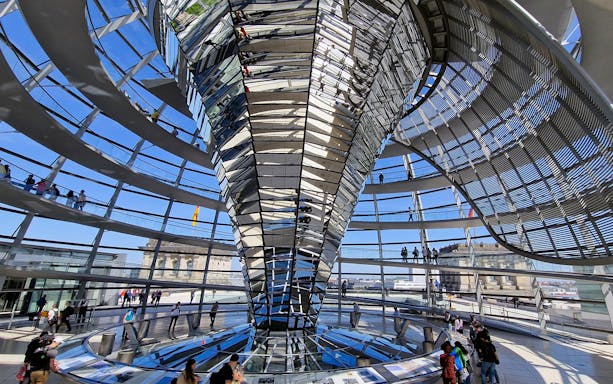 Interior view of the Reichstag dome in Berlin, showcasing the spiral walkway and glass structure.