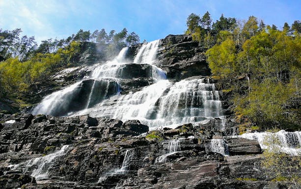 Tvindefossen waterfall cascading over rocky cliffs in Western Norway.