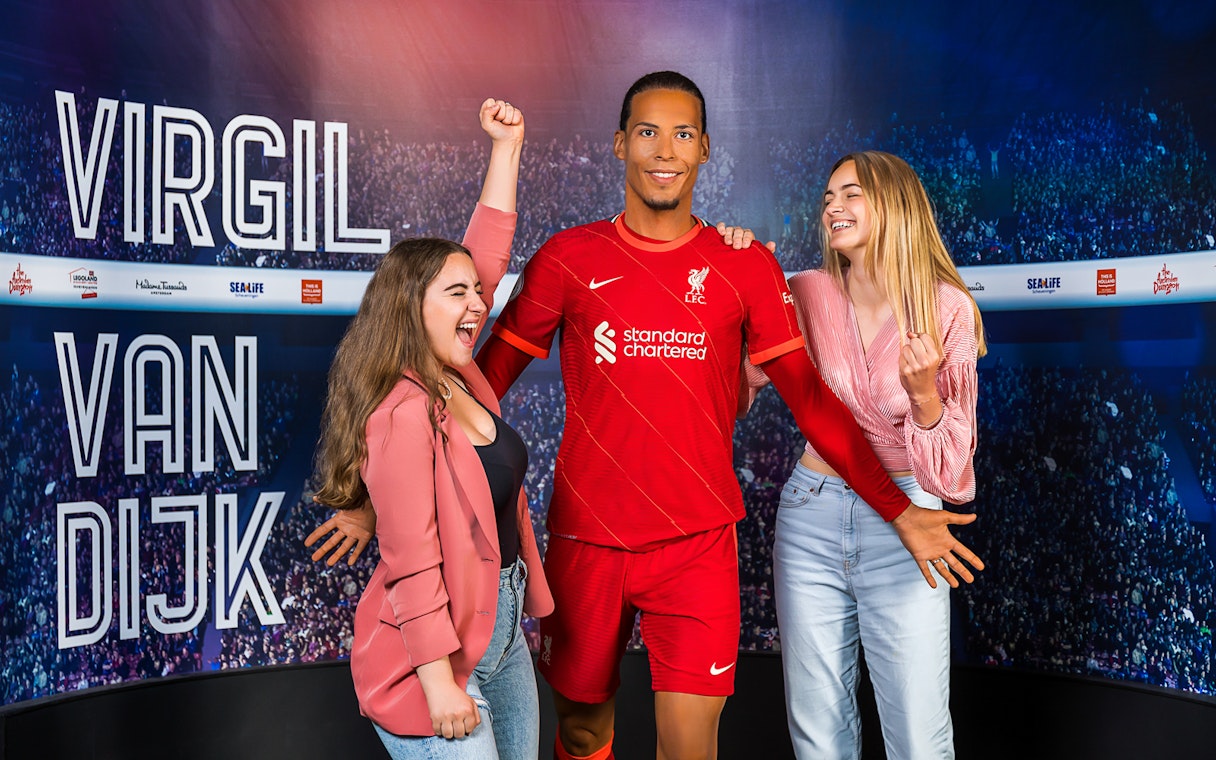Wax figure of Virgil Van Dijk with visitors at Madame Tussauds Amsterdam.