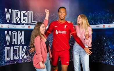 Wax figure of Virgil Van Dijk with visitors at Madame Tussauds Amsterdam.