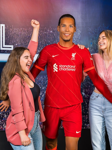 Wax figure of Virgil Van Dijk with visitors at Madame Tussauds Amsterdam.