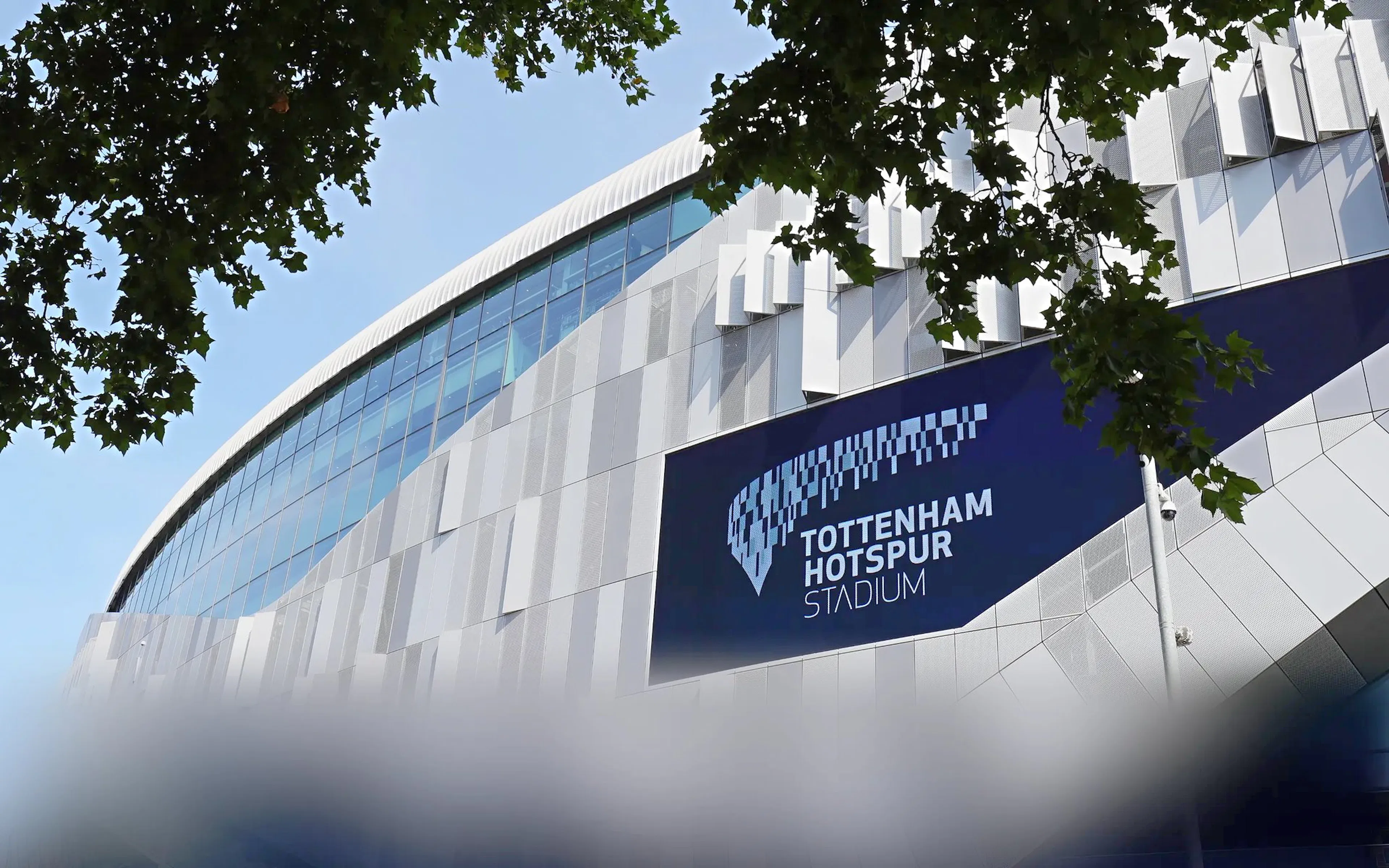 Tottenham Hotspur Stadium exterior with modern architecture and signage.