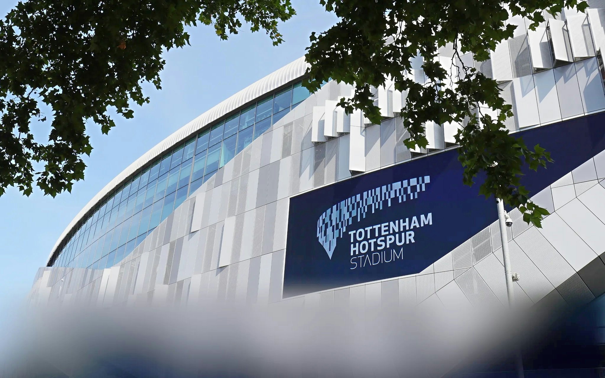 Tottenham Hotspur Stadium exterior with modern architecture and signage.