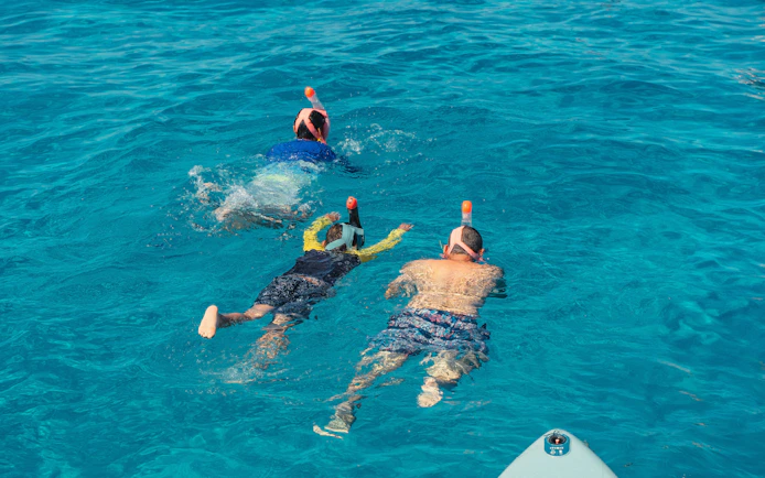 Snorkelers exploring clear waters at Cala Bassa beach, Ibiza, Spain.