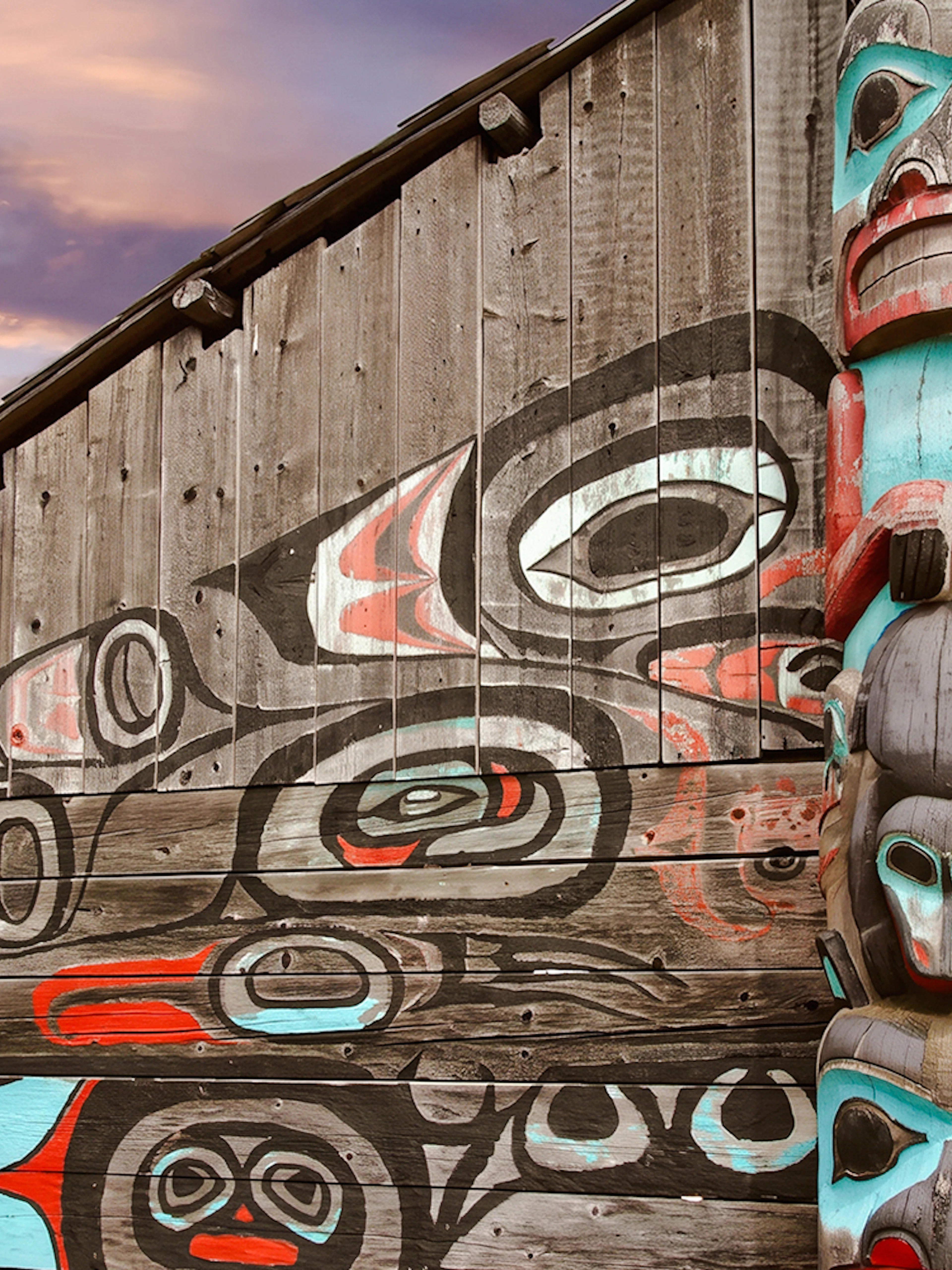 Totem pole and mural at a cultural site in Fairbanks, Alaska.