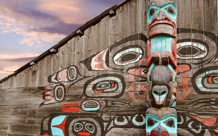 Totem pole and mural at a cultural site in Fairbanks, Alaska.