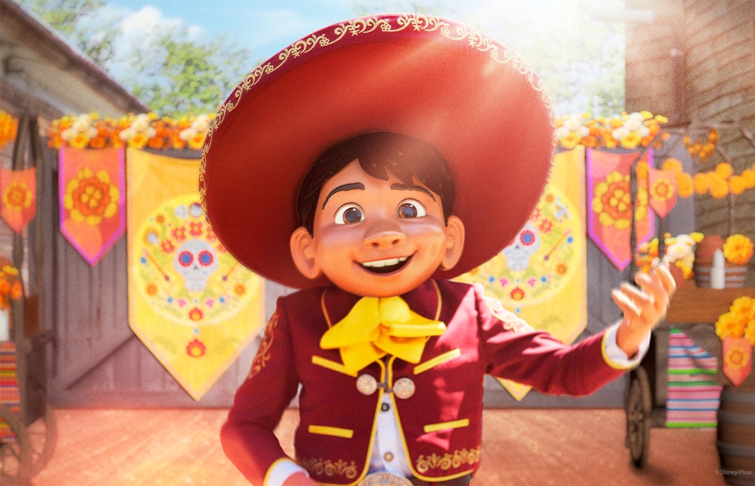 Character in traditional attire at Disneyland Paris with colorful decorations.