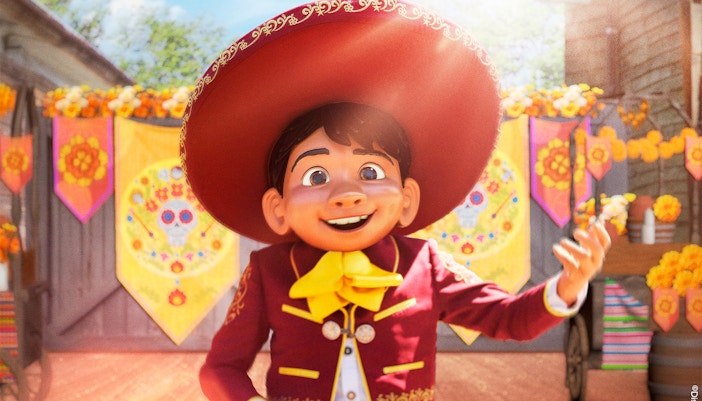 Character in traditional attire at Disneyland Paris with colorful decorations.