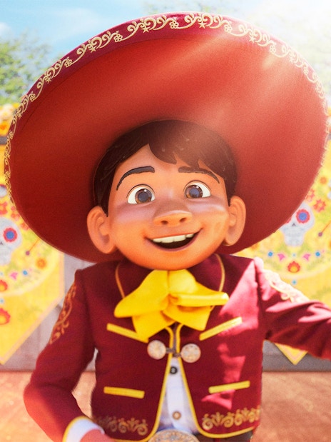 Character in traditional attire at Disneyland Paris with colorful decorations.