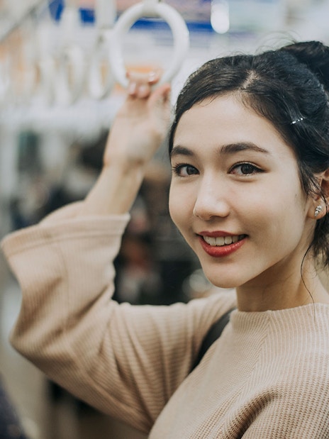 Woman holding onto a handrail in Tokyo subway.