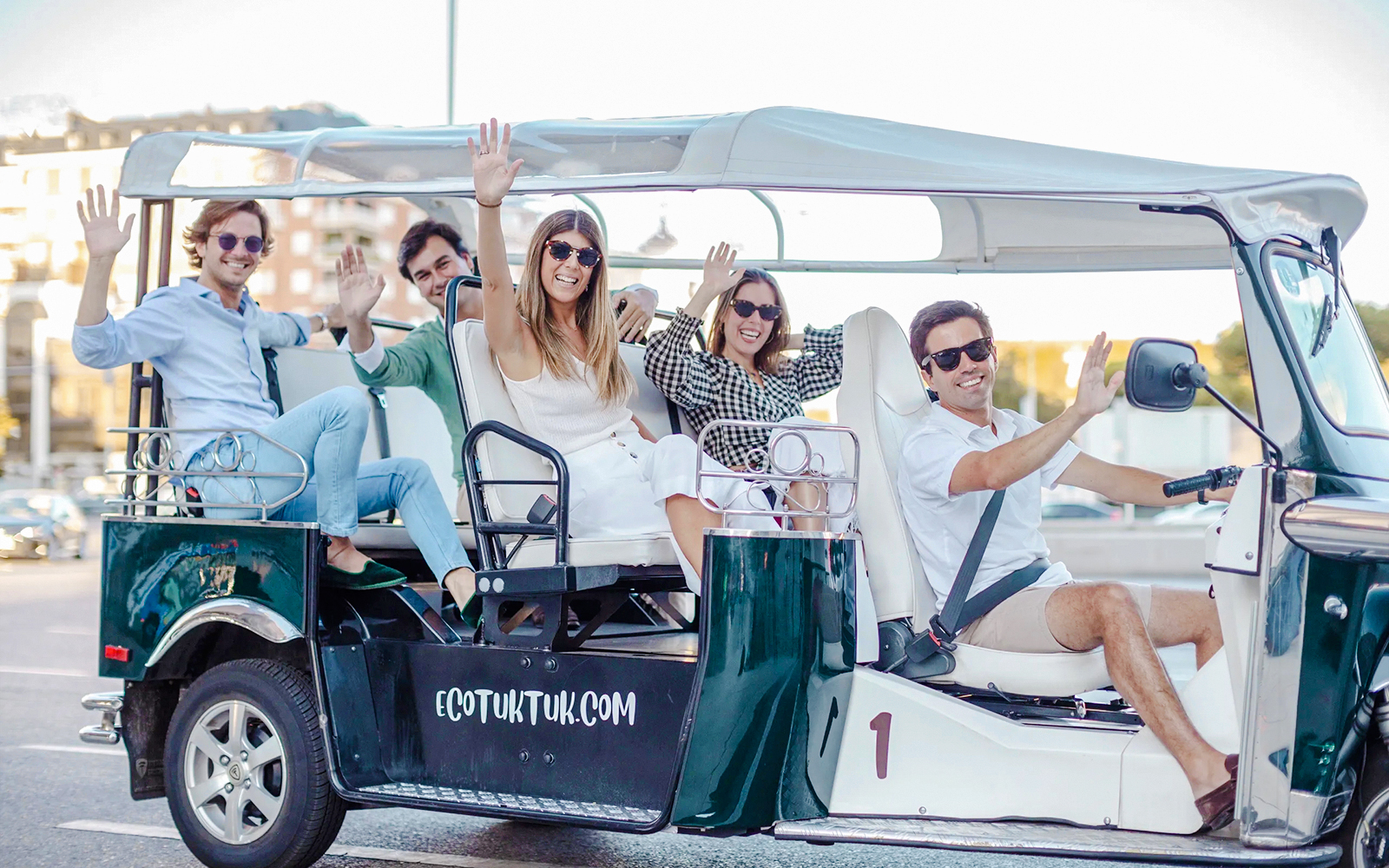 Tourists enjoying an electric tuk-tuk ride in Madrid, Spain.