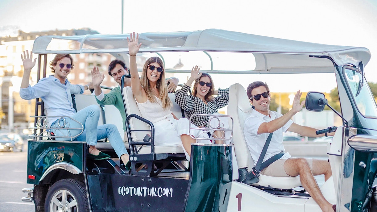 Tourists enjoying an electric tuk-tuk ride in Madrid, Spain.