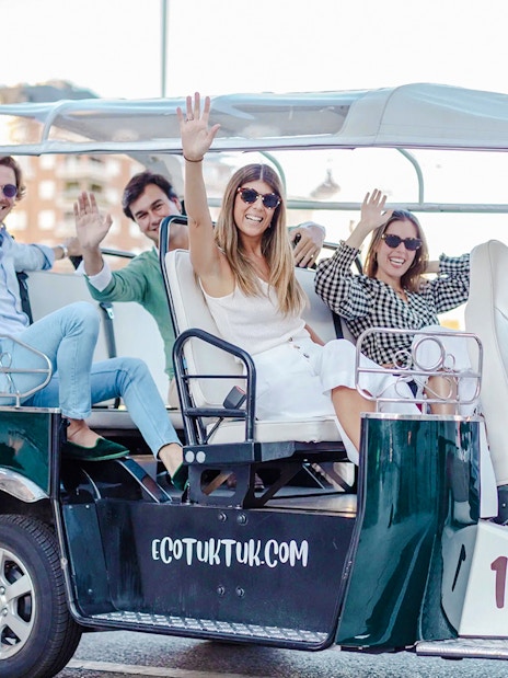 Tourists enjoying an electric tuk-tuk ride in Madrid, Spain.