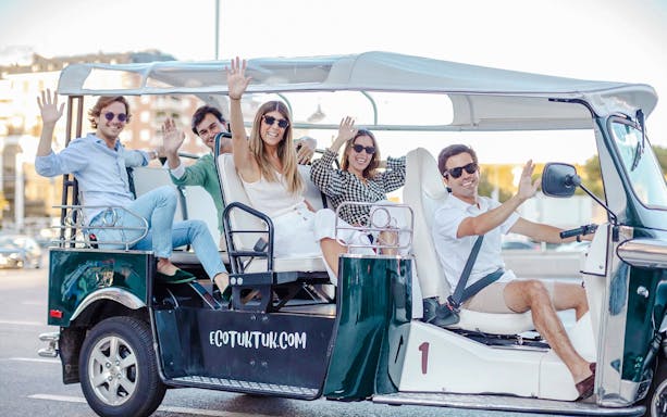Tourists enjoying an electric tuk-tuk ride in Madrid, Spain.