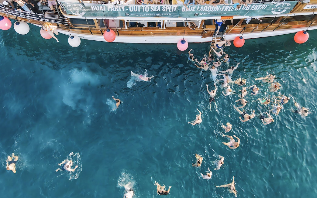 Participants swimming at a boat party in the Blue Lagoon, Split, Croatia.