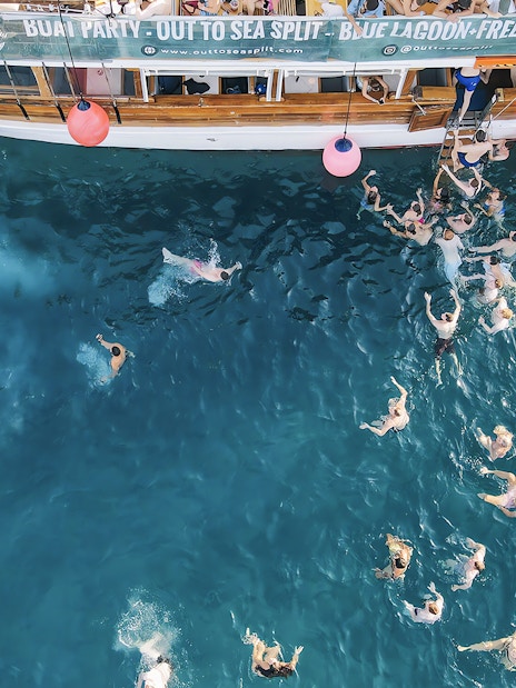 Participants swimming at a boat party in the Blue Lagoon, Split, Croatia.