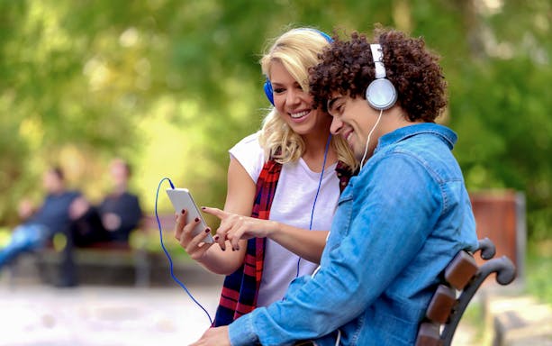 Couple listening to audio tour on phone for Quinta da Regaleira e-ticket.