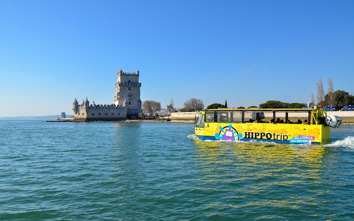 HIPPOtrip vehicle crossing water near Belém Tower, Lisbon.