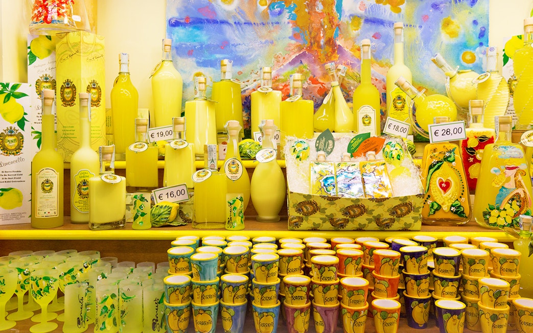Limoncello bottles and souvenirs on display in Amalfi shop during full-day tour from Rome.