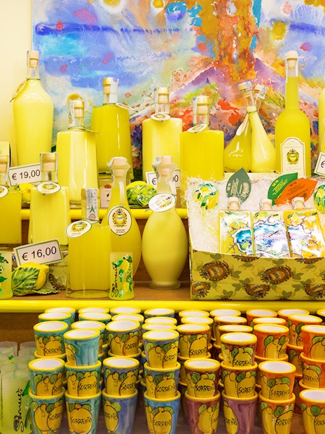 Limoncello bottles and souvenirs on display in Amalfi shop during full-day tour from Rome.