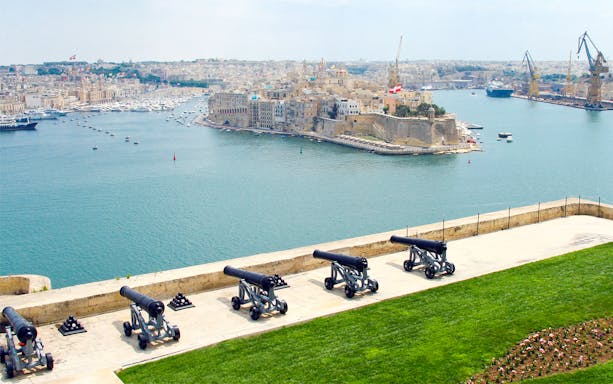 Valletta harbor view with historic cannons on a walking tour in Malta.