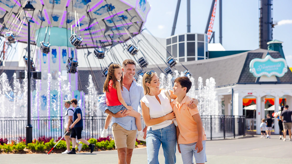 Family enjoying Main Street at Dreamworld, Gold Coast with fountains and rides in the background.