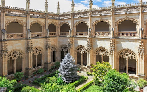 Cloister garden of the Monastery of San Juan de los Reyes, Toledo, with ornate arches.