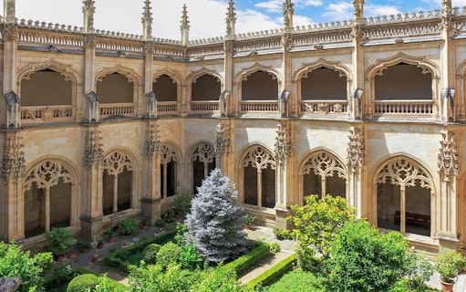 Cloister garden of the Monastery of San Juan de los Reyes, Toledo, with ornate arches.