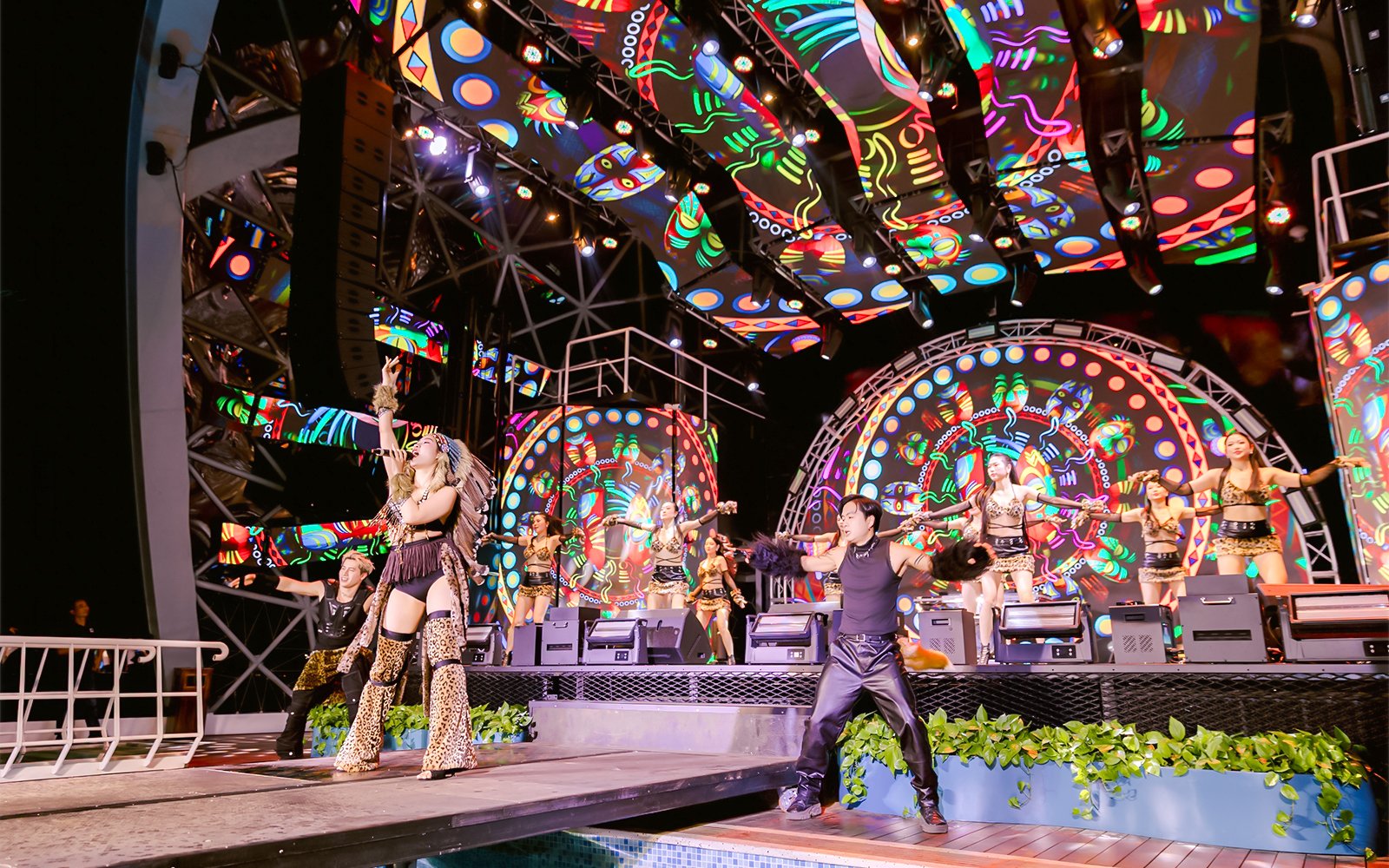 Performers on stage during a vibrant night show on a Dolphin cruise.