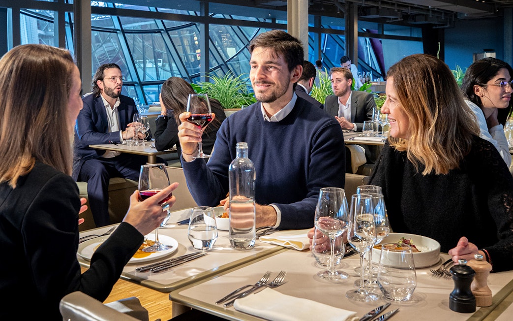 Tourists dining at a restaurant on the Eiffel Tower during a Paris day trip.